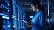 © SejutaCahaya - Female IT Specialist Uses Tablet in Data Center. Server Farm Cloud Computing Facility with Maintenance Administrator Working, Cyber Security Engineer Working in Personal Network Protection 1