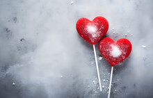 Two Red Lollipops Heart Shape On Grey Snowy Background Top View