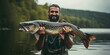 Portrait of candid happy angler holding huge trophy pike fish in hands standing on river water background