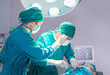 © JU.STOCKER - Medical team performing surgical operation in operating Room, Concentrated surgical team operating a patient