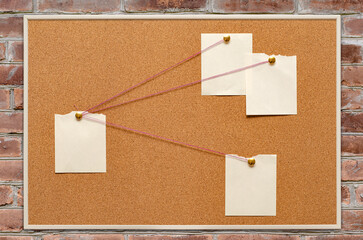 Blank paper notes are pinned to a cork board. The concept of detective investigation. Copy space.