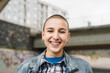 Happy young woman with shaved head smiling in front of camera