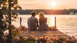 A romantic couple just in love sitting on a lakeside pier with flowers behind them