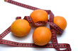 Pomarańcze leżą owinięte centymetrem na białym tle