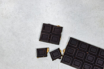 black almond chocolate bar isolated on grunge gray background from top view