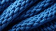 An intricate knot of soft blue fibers, resembling a tightly woven rope, creates a cozy and comforting texture on the knitted fabric