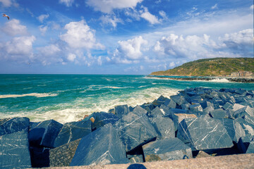 Wall Mural - Landscape with sea and cliffs. Rocky seashore on a sunny day. Beautiful nature landscape. Stormy sea. San Sebastian, Basque Country, Spain