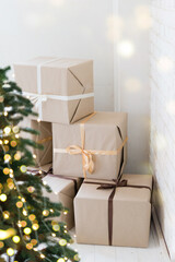 Poster - Christmas home interior. Boxes with gifts. Christmas tree with garland lights is blurred in the background. Holiday decor.