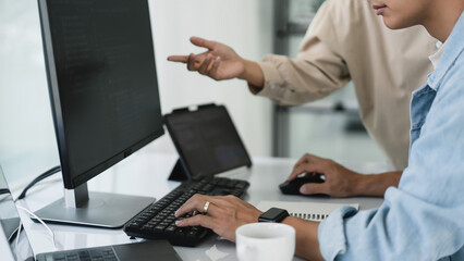 Wall Mural - two developer programmer discussing and typing code on keyboard for programming to developing web