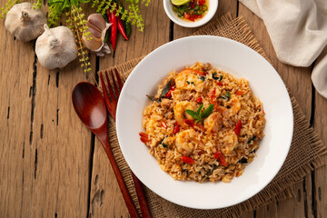 Wall Mural - Spicy Shrimp and minced pork Fried Rice with thai holy basil leaves in white plate.Top view