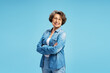 © Maria Vitkovska - Smiling beautiful senior elderly woman wearing glasses, stylish blue shirt with arms crossed, standing isolated on blue background. Pensioner concept