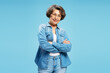 © Maria Vitkovska - Portrait of confident senior woman wearing eyeglasses and stylish denim shirt, arm crossed isolated on blue background. Advertisement concept