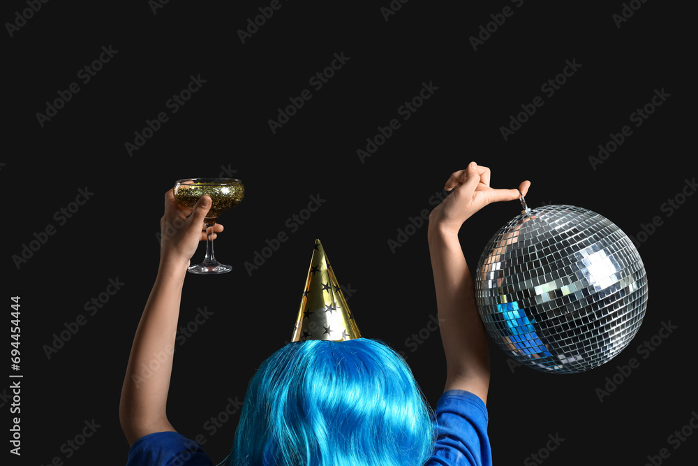 Woman with glass and disco ball on black background
