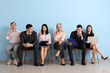 © Pixel-Shot - Applicants waiting for job interview near blue wall