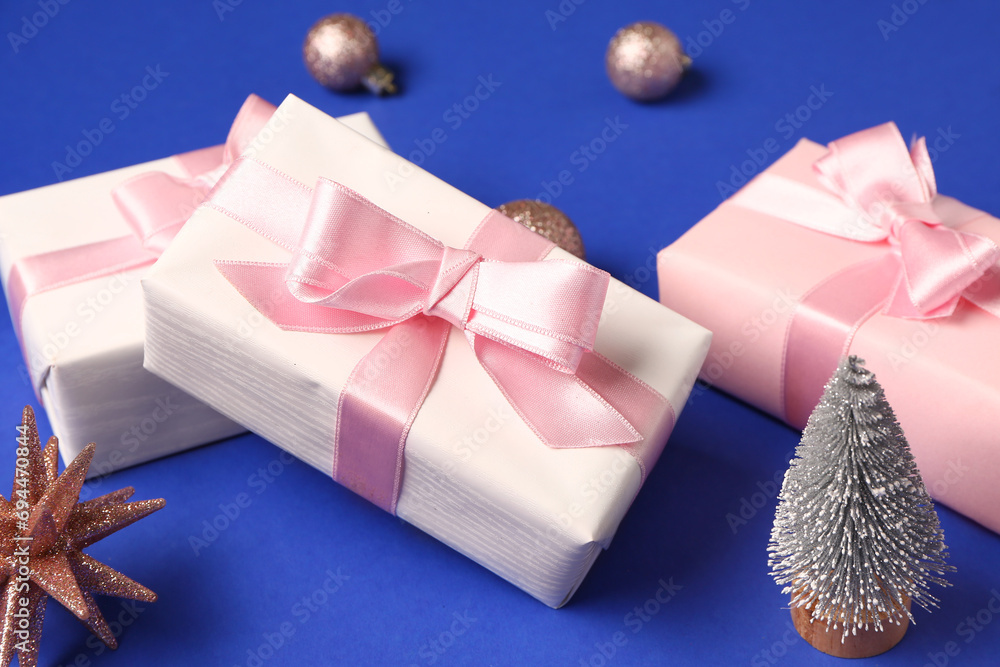 Pink gift boxes and Christmas decorations on blue background
