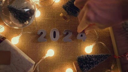 Wall Mural - b roll - hands of woman put 2024 numbers on decorated table, merry christmas and happy new year!