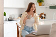 © Pixel-Shot - Young pregnant woman with cup of tea using laptop in kitchen