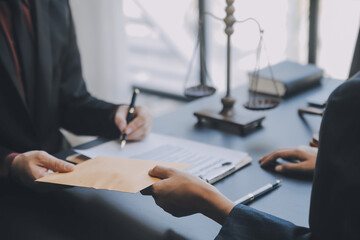 Business and lawyers discussing contract papers with brass scale on desk in office. Law, legal services, advice, justice and law concept picture with film grain effect