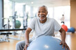 © ZAY WIN HTAI - Senior African man doing exercise with a swiss ball at a gym