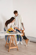 © Pixel-Shot - Young couple with Beagle dog at table during repair in their new house