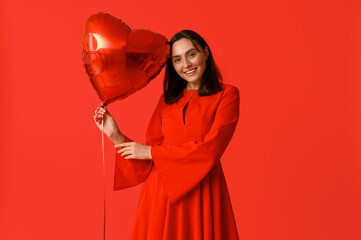 Sticker - Beautiful young woman with air balloon in shape of heart on red background. Valentine's Day celebration