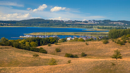 Wall Mural - A large body of water surrounded by a lush green hillside.