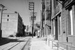 © trekandphoto - Grainy archival 1985 black and white film photograph of Banning Street near Santa Fe Ave in downtown Los Angeles California.  The brick warehouses have been torn down.