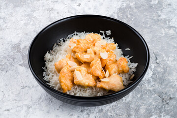 Poster - Boiled rice with fried chicken fillet and almonds in a bowl.