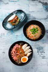 Canvas Print - Rice with chicken, dashi broth and flatbread with beef and vegetables on a table.