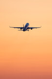 Fototapeta Storczyk - Plane takeoff at sunset.