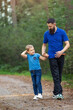 © Linas T - A walk along the forest path in the evening, a beautiful contact between a father and his little son, they are holding hands.