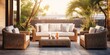 Outdoor wicker furniture set includes cozy sofa, armchairs, pillows, and coffee table.