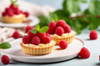 Vanilla tartlets with raspberries on light background