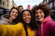 © koala studio - Multiethnic group of friends taking selfie with mobile phone on the street