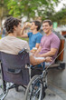 © Guillermo Spelucin - Disabled man and friends having a conversation in the park