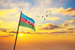 Waving flag of Azerbaijan against the background of a sunset or sunrise. Azerbaijan flag for Independence Day. The symbol of the state on wavy fabric.