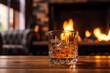 Glass of cognac or whiskey. Blur burning fireplace background.