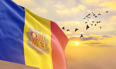 Waving flag of Andorra against the background of a sunset or sunrise. Andorra flag for Independence Day. The symbol of the state on wavy fabric.