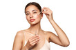 © Oleg Gekman - Young beautiful woman applying face serum with pipette. Cosmetic procedures for facial skin care