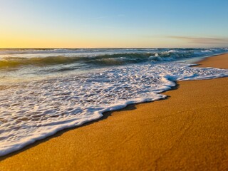 Sandy ocean shoreline, empty beach, warm evening light