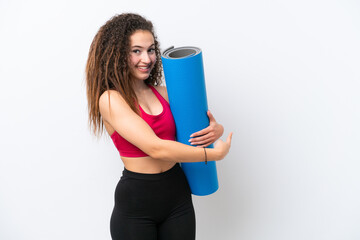 Canvas Print - Young sport Arab woman going to yoga classes while holding a mat isolated on white background pointing back