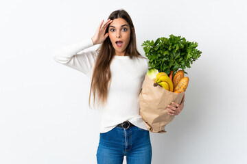 Canvas Print - Young caucasian woman buying some food isolated on white background with surprise expression