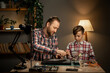 A father teaches his son how to repair a broken laptop and a damaged hard drive, a hobby for children and parental help