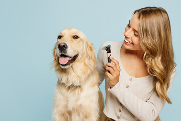 Wall Mural - Young owner woman wear casual clothes hug cuddle best friend retriever dog hold grooming brush trim at salon isolated on plain pastel light blue background studio portrait Take care about pet concept
