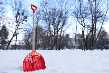 Wall Mural - Snow shovel with wooden handle outdoors. Space for text