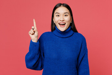 Wall Mural - Young insighted smart proactive woman of Asian ethnicity she wear blue sweater casual clothes holding index finger up with great new idea isolated on plain pastel pink background. Lifestyle concept.