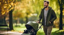 Adult Man Or Father With Stroller Or Perambulator In The City Park With Green Grass On A Sunny Autumn Day. Young Dad Parent Walking And Pushing Baby Carriage Or Pushchair With Teddy Bear
