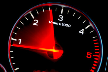 Motion blur of a car instrument panel dashboard odometer with red illuminated display.Car speedometer. High speed car speedometer and motion blur at night.