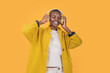© ADDICTIVE STOCK - Happy black young woman enjoying music through wireless headphones