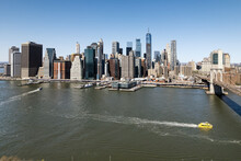 Manhattan Skyline And Brooklyn Bridge With Yellow Water Taxi